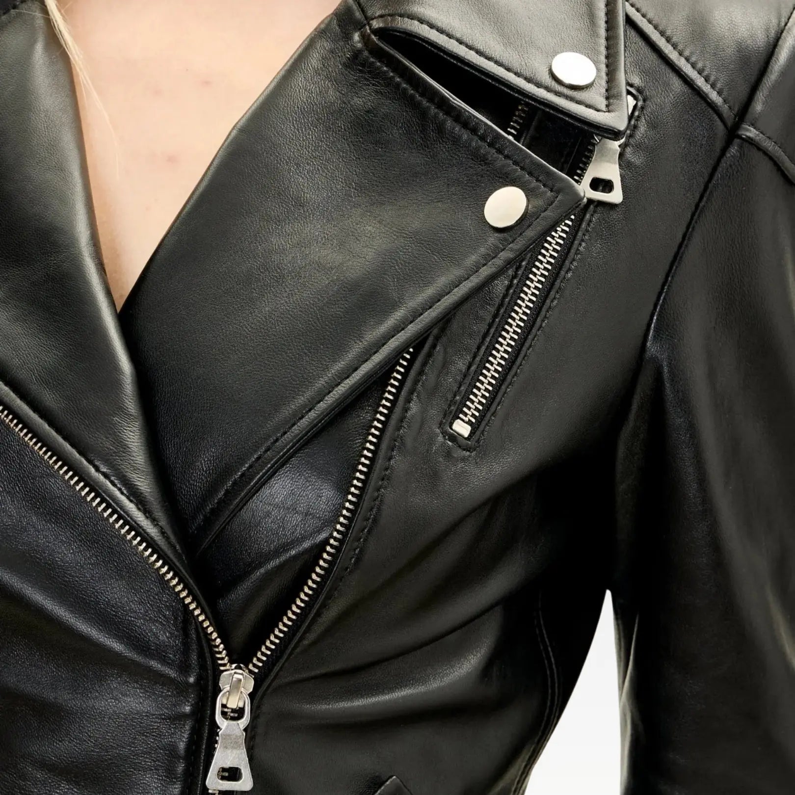 Black lambskin leather peplum jacket full outfit with high-waisted jeans and boots, showcasing a tailored hourglass silhouette and elegant moto style.