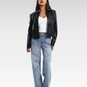 Stylish black leather jacket worn by a woman with raised arms, paired with light blue jeans and a white top, emphasizing its comfortable fit and edgy zippered sleeves for winter fashion.