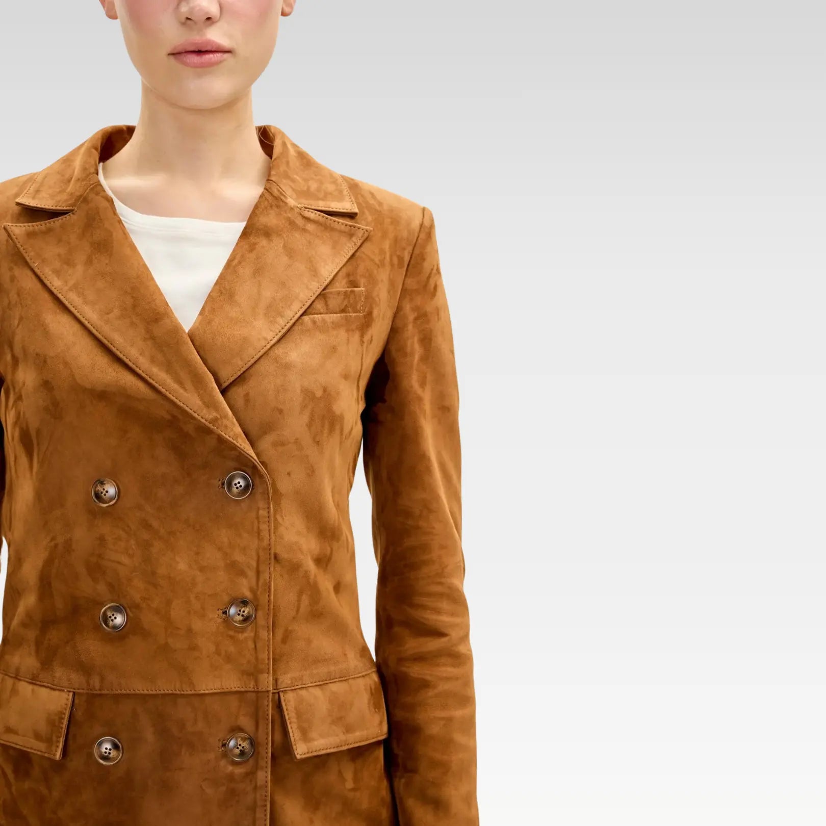 Close-up of brown lambskin suede double-breasted jacket featuring six-button front, peak lapels, and chest pocket.