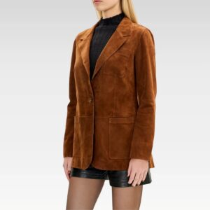 Close-up of brown suede lambskin blazer showing stitched lapels, chest pocket, and soft suede texture.