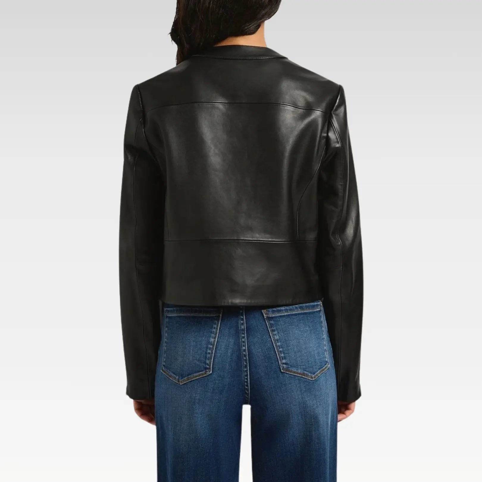 Close-up detail of Rebecca black genuine leather biker jacket showing soft leather texture, center zip fastening, and collarless modern design