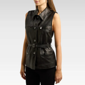 Front view of a woman wearing a sleek sheepskin leather vest with a detachable belt, black color, button fastening, and zippered pockets.