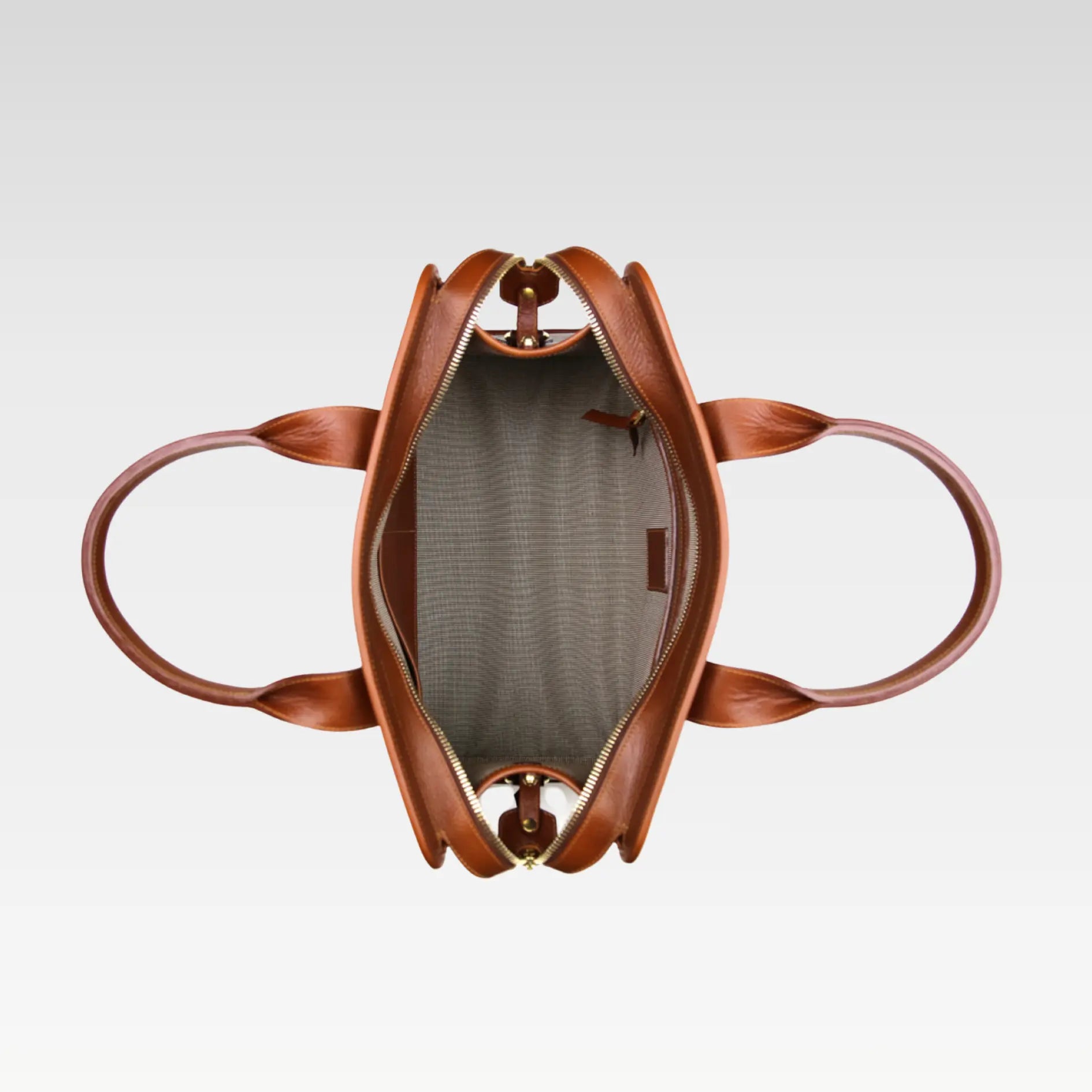 Top view of the open Signature Weekender Leather Duffle showing its pulister lining, dual slip pockets, and secure zipper pocket for organized travel.