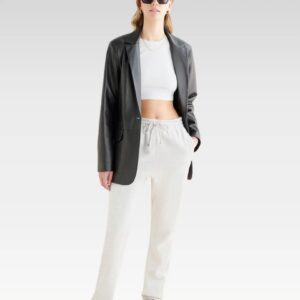 Full front view of model wearing Stand Studio Mina blazer in genuine leather paired with white outfit, illustrating relaxed fit and versatile styling.