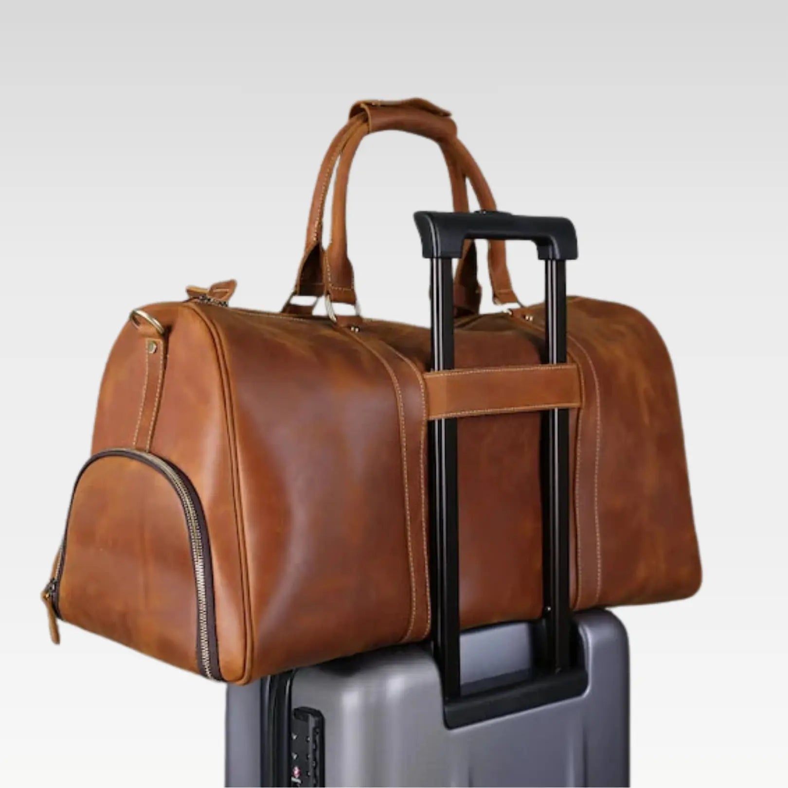 Full-display image of The Voyager leather duffle bag showing handles, main compartment, and travel-ready design.