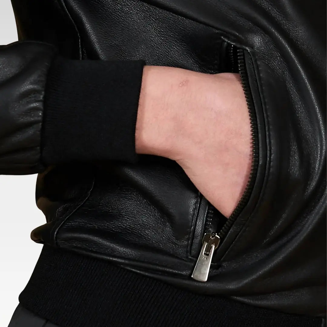 Women's cropped washed leather bomber jacket in black, model standing to show the cropped fit and ribbed details, crafted from responsibly sourced genuine leather